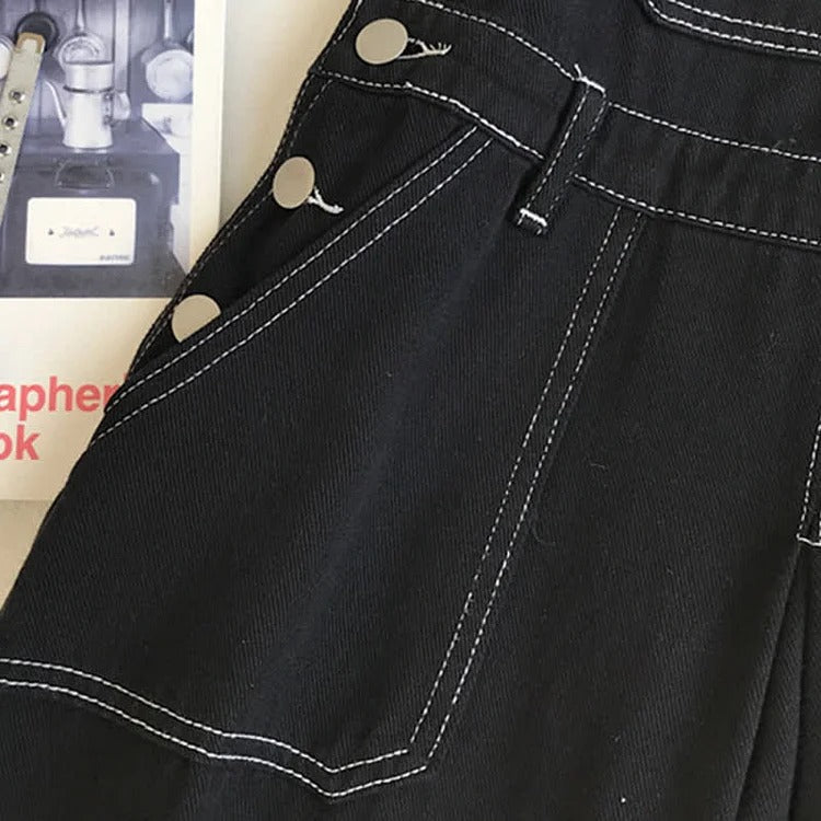Black denim overall dress with white stitching detail, long sleeves, and strawberry embroidered shirt.