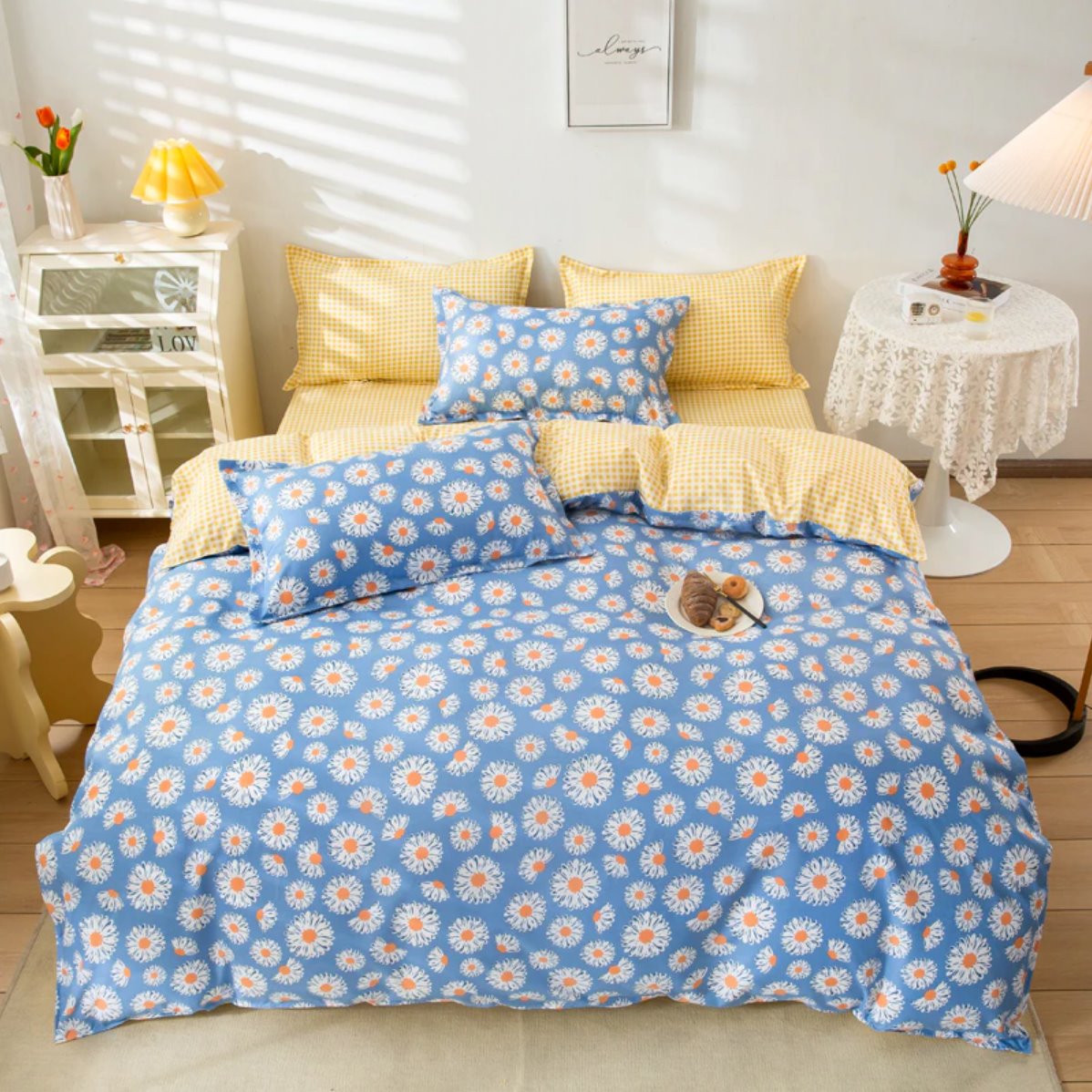 Blue daisy bedding set with yellow gingham accents. Includes duvet cover, flat sheet, and pillowcases. Soft polyester microfiber.