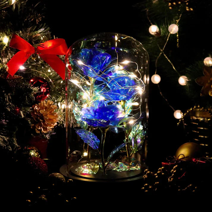 Illuminated blue iridescent rose preserved in glass dome with warm LED lights, on wooden base.  Perfect gift.