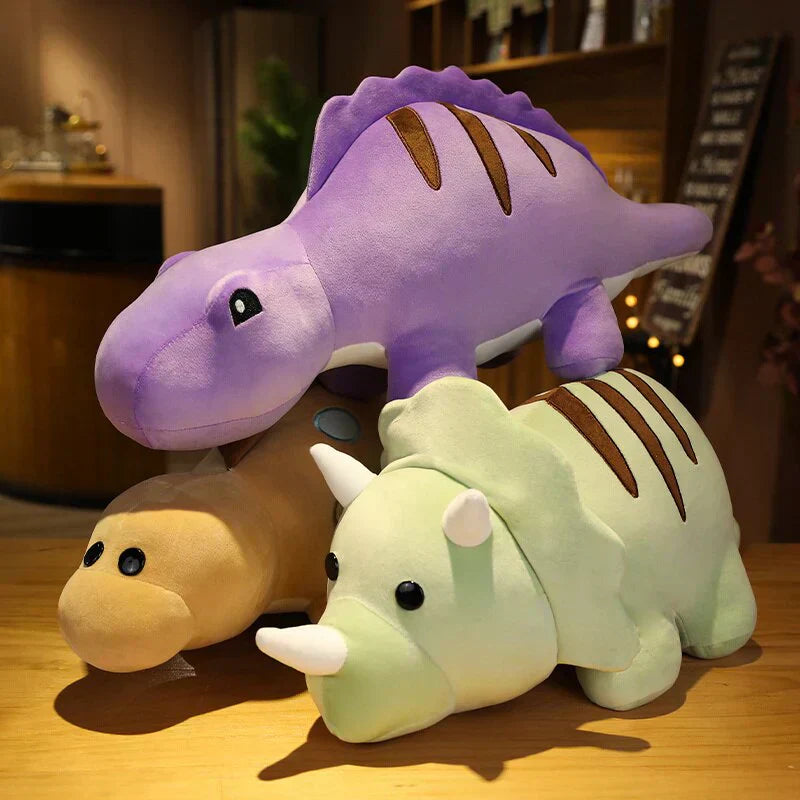 Three cute chibi dinosaur plush toys: purple stegosaurus, light green triceratops, tan brachiosaurus. Soft PP cotton, 3 sizes.