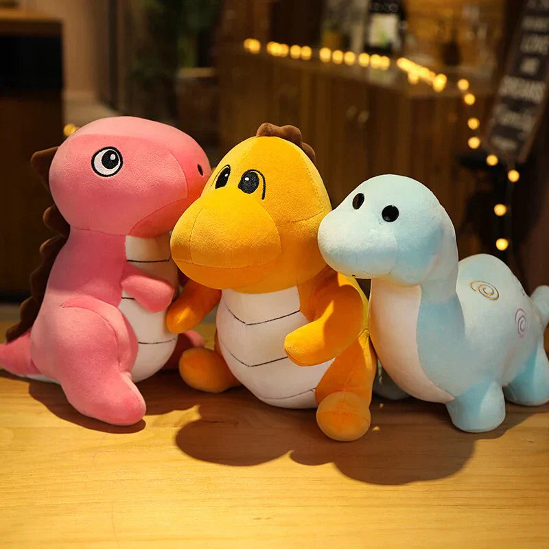 Three adorable chibi dinosaur plush toys in pink, orange, and light blue. Made of soft PP cotton, these cuddly dinos are perfect for snuggling.