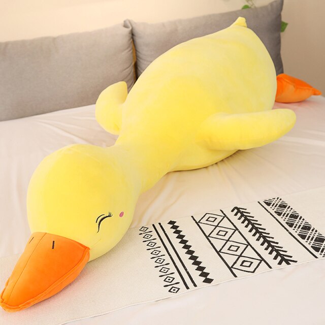 Giant yellow Flora swan plush pillow; soft PP cotton filling; hypoallergenic; promotes relaxation; various sizes available.