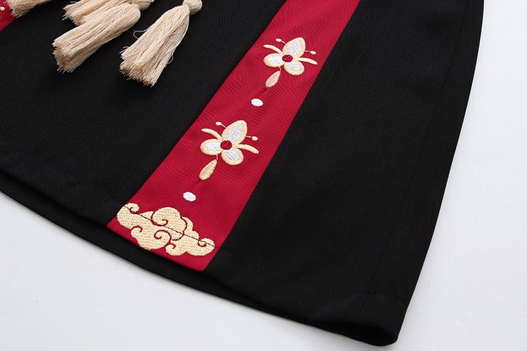 Black mini skirt with red embroidered panels, gold cloud details, and beige tassels; paired with a matching lucky cat hoodie.