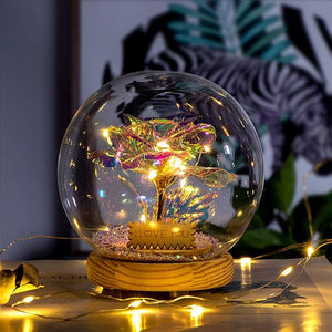 Illuminated preserved red rose in glass dome; LED lights create galaxy effect; wooden base; perfect romantic gift.