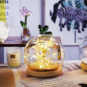 Illuminated red rose in glass dome with wooden base; LED lights create galaxy effect. Perfect gift.