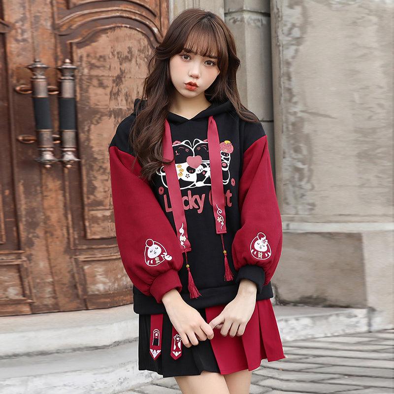 Red & black lucky cat hoodie & skirt set; features cartoon cat print, tassels, and cat paw details.  Soft cotton.