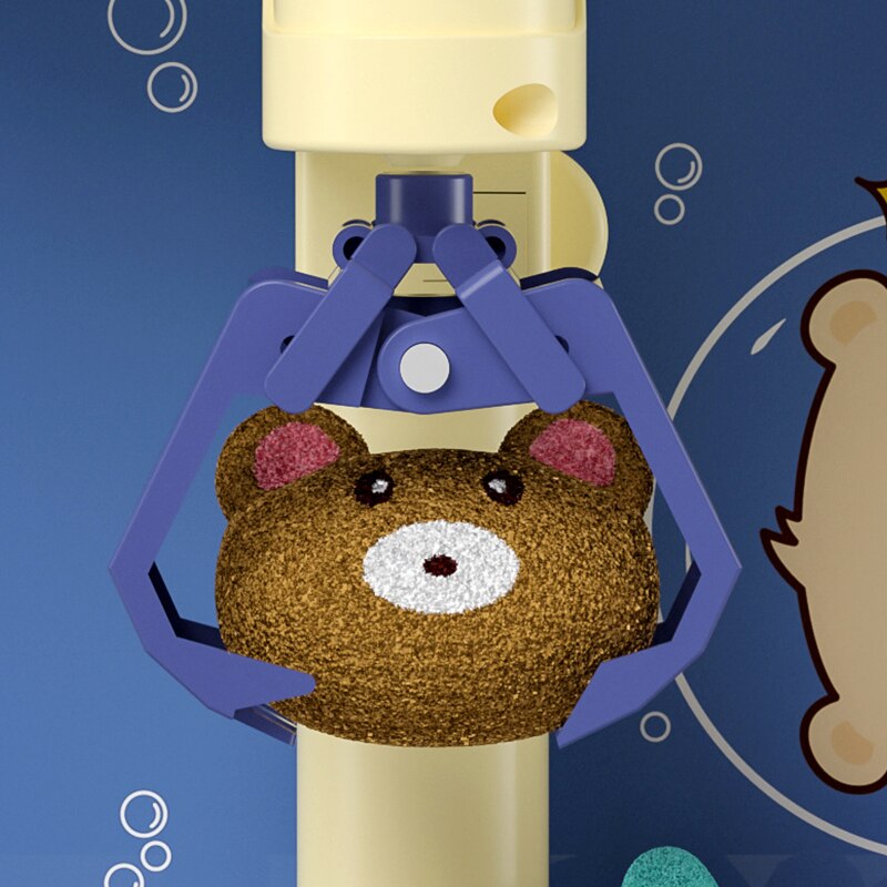 Mini claw machine with ocean theme; brown bear plush prize; purple claw; yellow base; lights & sounds; 18x15x29cm.