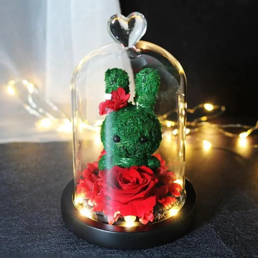 Glass dome LED display featuring a preserved red rose and mossy green bunny; perfect gift.