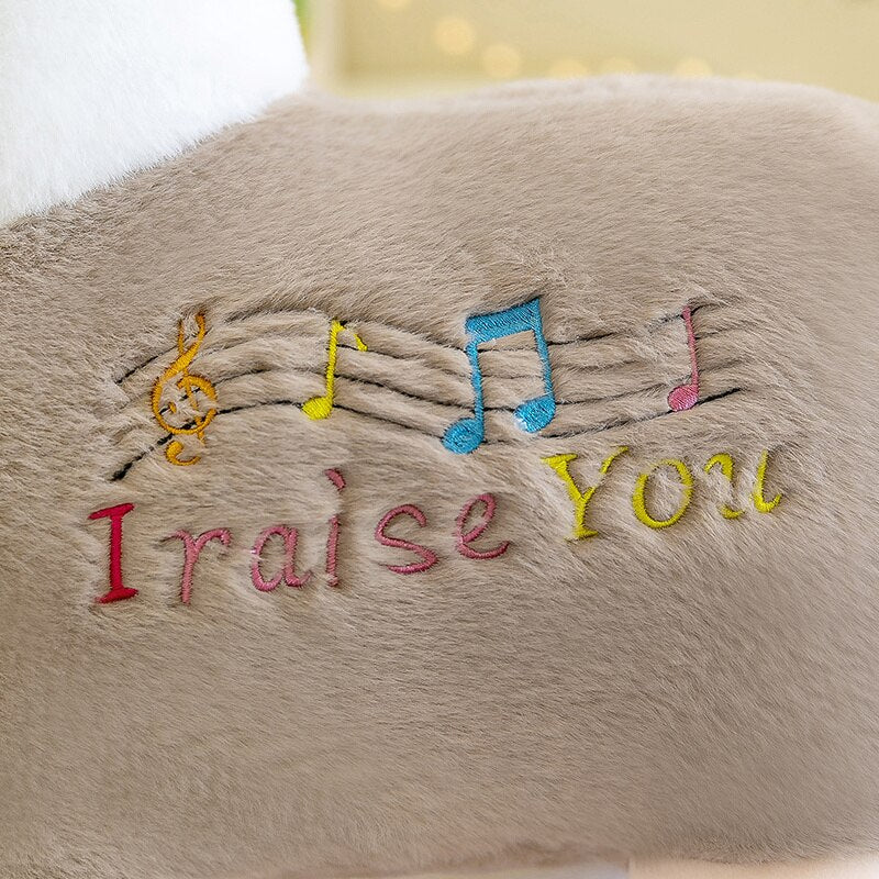 Beige musical alpaca plush toy; soft cotton, "I raise you" embroidery, colorful musical notes.