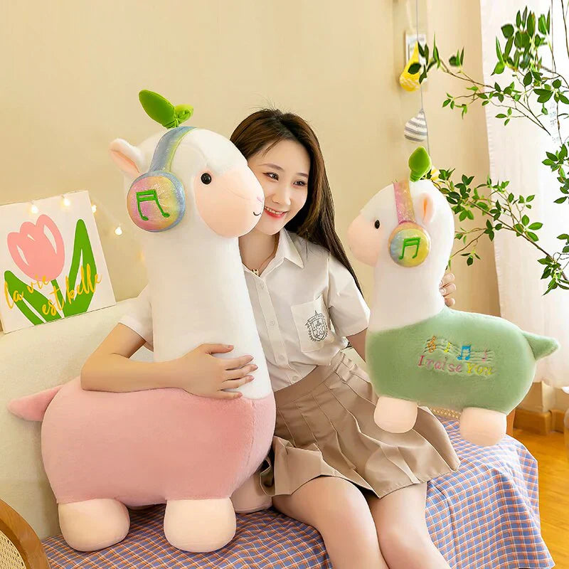 Adorable musical alpaca plush toy; soft cotton, pastel pink & green; features headphones; ethically sourced.