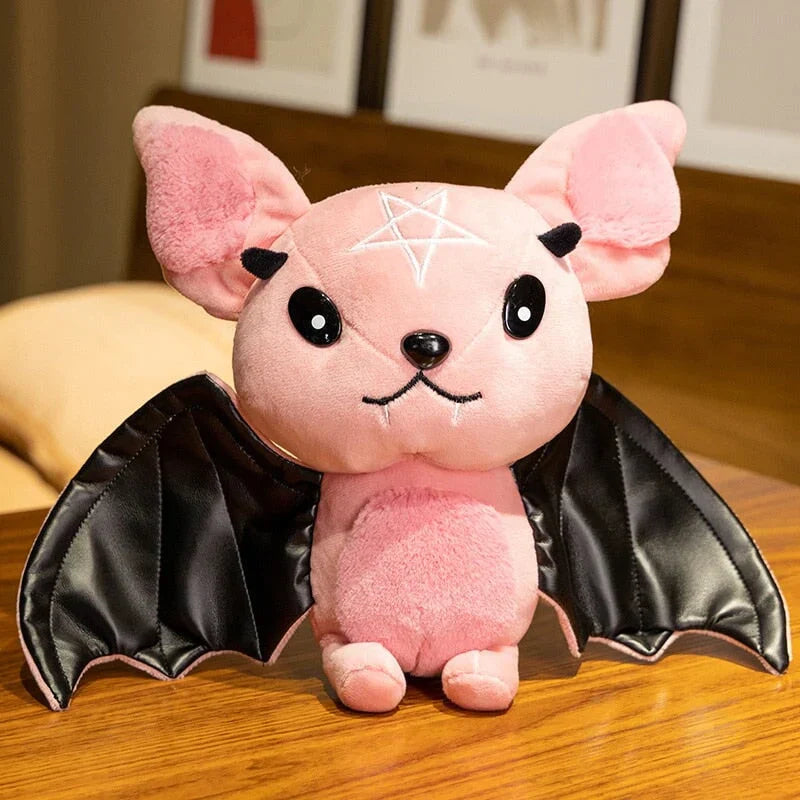 Pink kawaii bat plush toy with black faux leather wings, pentagram detail, and soft PP cotton filling.