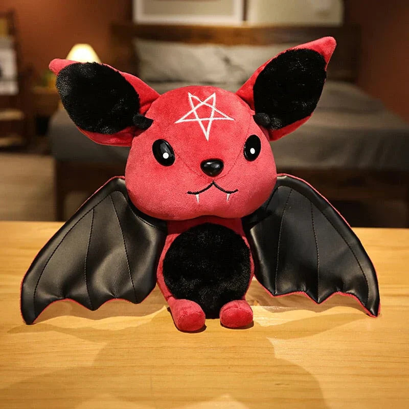 Red kawaii bat plush toy with black faux leather wings and pentagram detail. Soft PP cotton filling. Halloween gift.