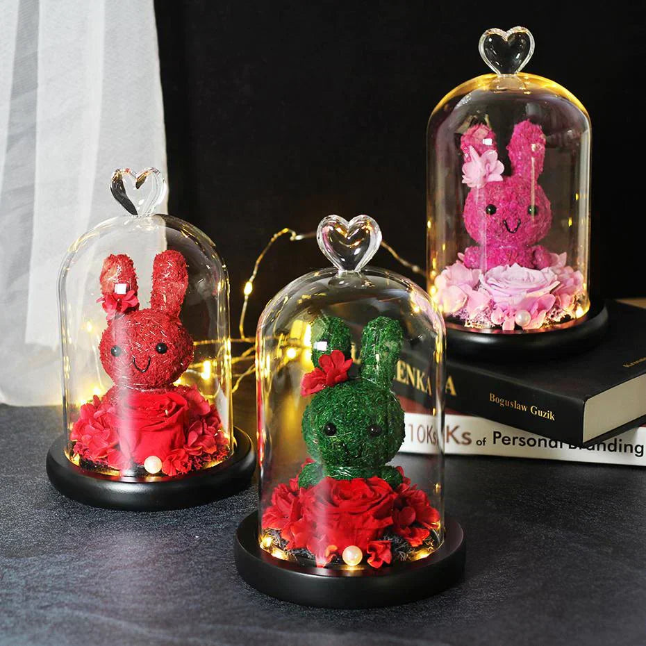 LED-lit glass dome display featuring a preserved rose and bunny.  Perfect gift, available in various colors. 12x20cm.