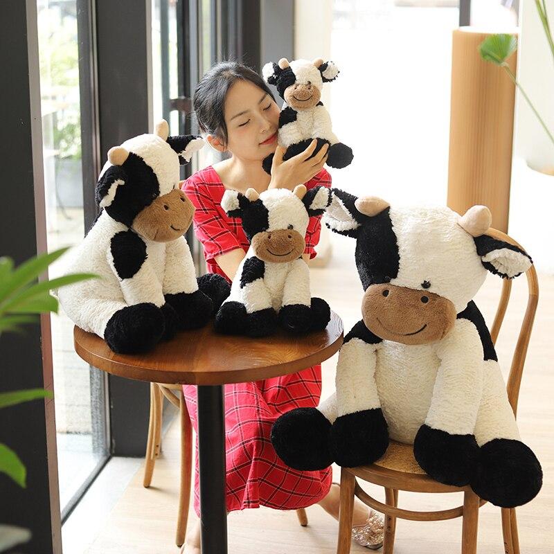 Soft white and black spotty cow plush toy, made with premium PP cotton.  Huggable and hypoallergenic, perfect for cuddling.