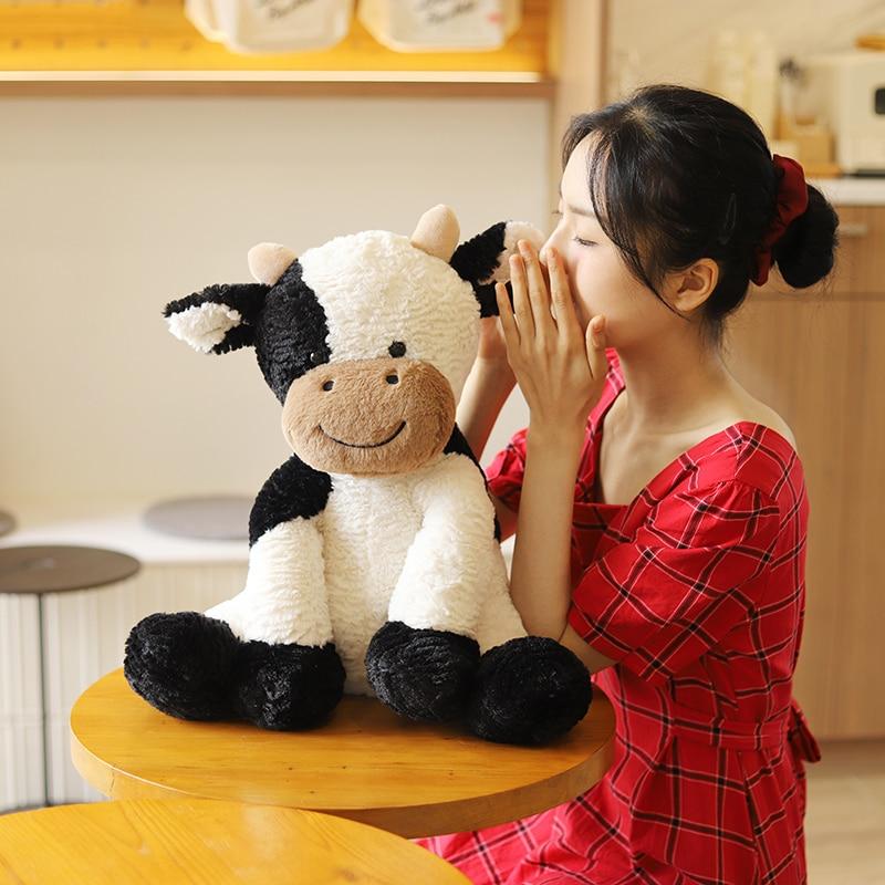 Adorable spotty cow plush toy, white with black spots, made of soft PP cotton. Hypoallergenic & perfect for cuddling.