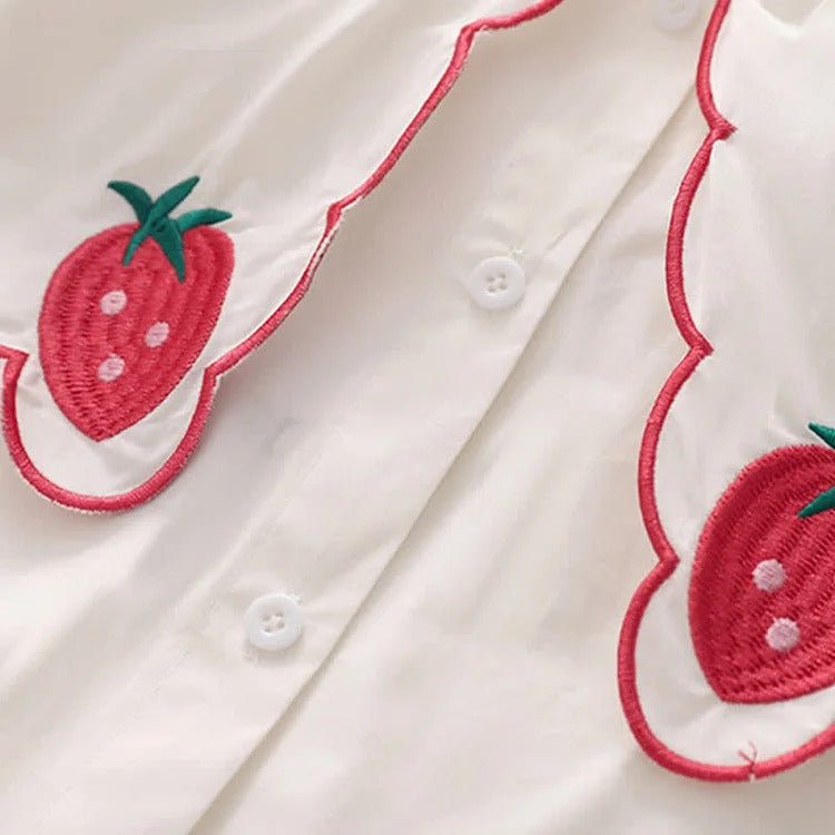 White polyester shirt & black denim overall dress. Strawberry embroidery adorns the Peter Pan collar. Long sleeves, long dress length. Preppy style.